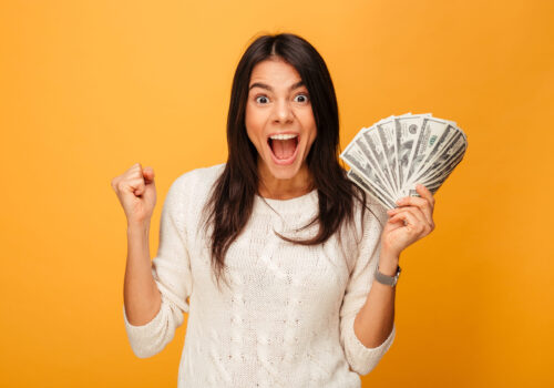 Portrait,Of,An,Excited,Young,Woman,Holding,Money,Banknotes,And