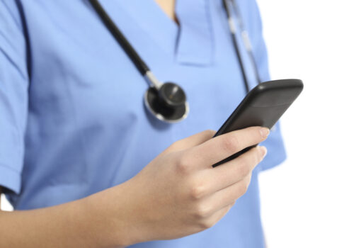 Close up of a nurse hand using a smart phone isolated on a white background