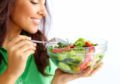 Close-up of pretty girl eating fresh vegetable salad