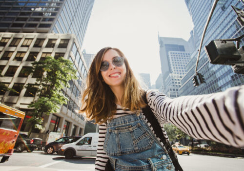 Pretty,Female,Girl,Tourist,Smiling,And,Taking,Selfie,In,Manhattan,